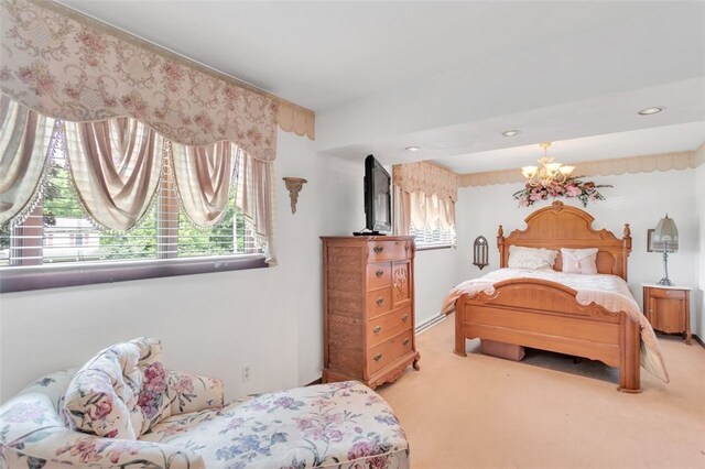 bedroom with carpet floors, baseboard heating, and an inviting chandelier