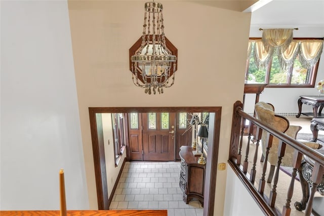 tiled foyer entrance featuring a chandelier