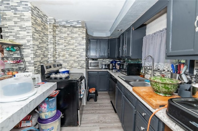 kitchen with stainless steel appliances, decorative backsplash, light hardwood / wood-style flooring, and sink