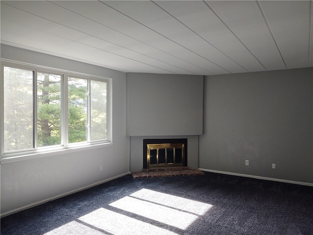 unfurnished living room featuring carpet and a brick fireplace