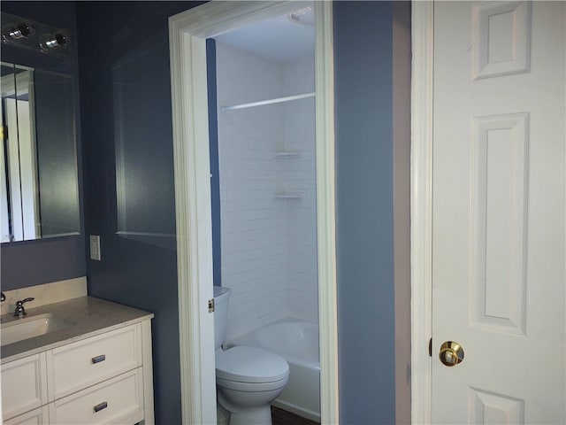 full bathroom featuring tiled shower / bath, vanity, and toilet