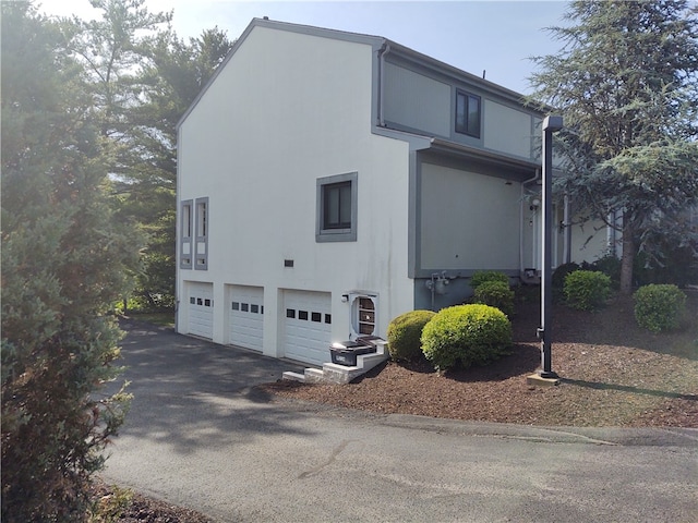 view of side of property featuring ac unit and a garage