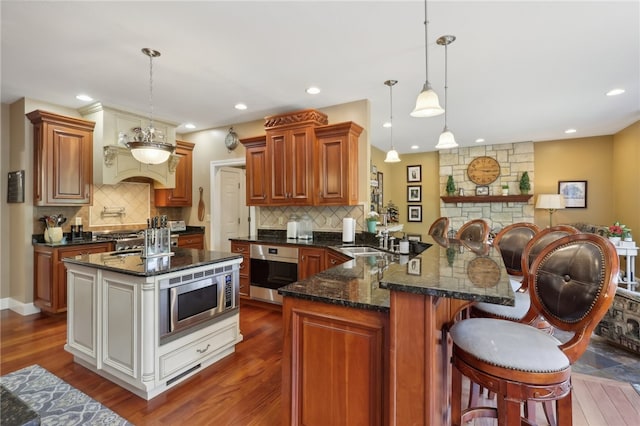 kitchen with stainless steel appliances, hanging light fixtures, and tasteful backsplash