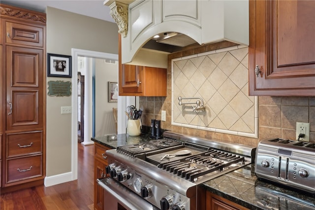 kitchen with backsplash, stove, and dark hardwood / wood-style floors