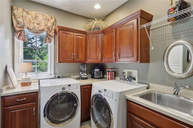 laundry area with hookup for a washing machine, electric dryer hookup, sink, washer and clothes dryer, and cabinets