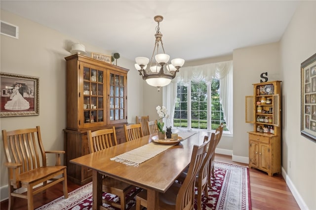 dining room with a notable chandelier and light hardwood / wood-style flooring