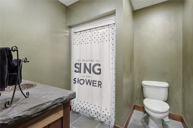 bathroom featuring tile flooring, vanity, and toilet