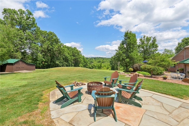 view of patio featuring a fire pit and an outdoor structure