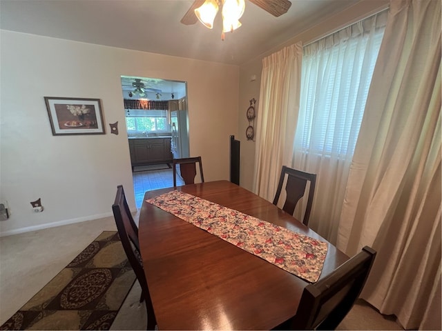 carpeted dining room featuring ceiling fan