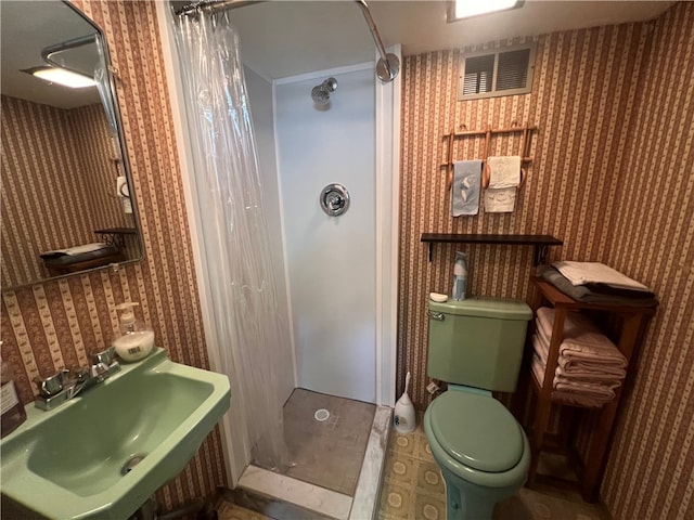 bathroom featuring sink, walk in shower, tile flooring, and toilet