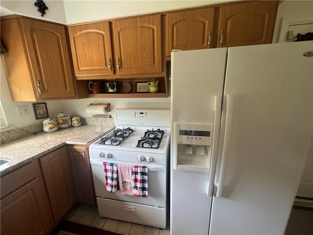 kitchen featuring white appliances and light tile flooring