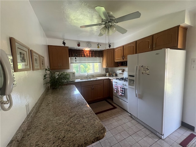 kitchen with white appliances, sink, light tile flooring, and ceiling fan