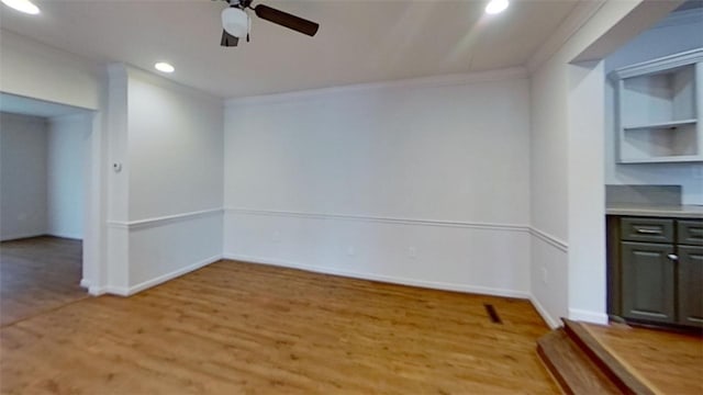 spare room featuring crown molding, ceiling fan, and light wood-type flooring