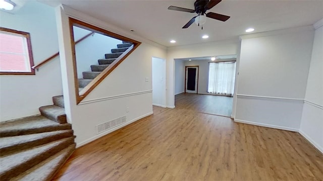 unfurnished living room with ceiling fan, light hardwood / wood-style floors, and crown molding