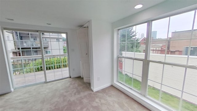 doorway featuring light carpet and a healthy amount of sunlight