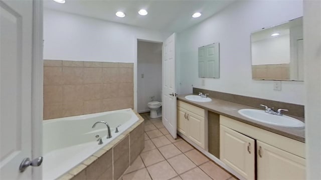 bathroom featuring tile patterned floors, vanity, a relaxing tiled tub, and toilet