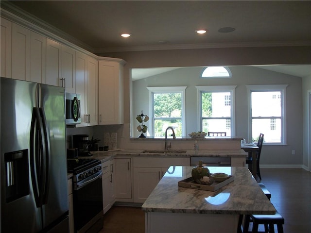 kitchen featuring appliances with stainless steel finishes, white cabinetry, sink, light stone counters, and crown molding