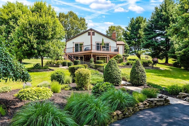 back of house featuring a wooden deck and a lawn