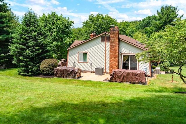 view of property exterior with central AC, a patio, and a lawn