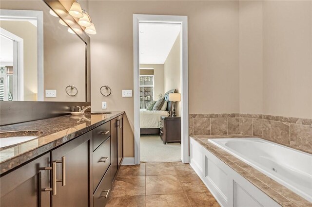 bathroom featuring tiled tub, dual vanity, and tile patterned floors