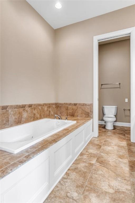 bathroom featuring tile patterned floors, a bathtub, and toilet