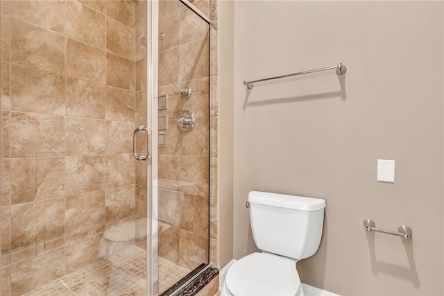 bathroom with a shower with door and toilet