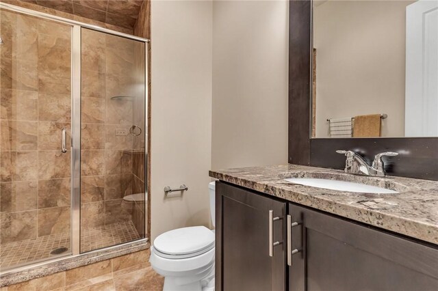 bathroom with walk in shower, tile patterned flooring, toilet, and vanity