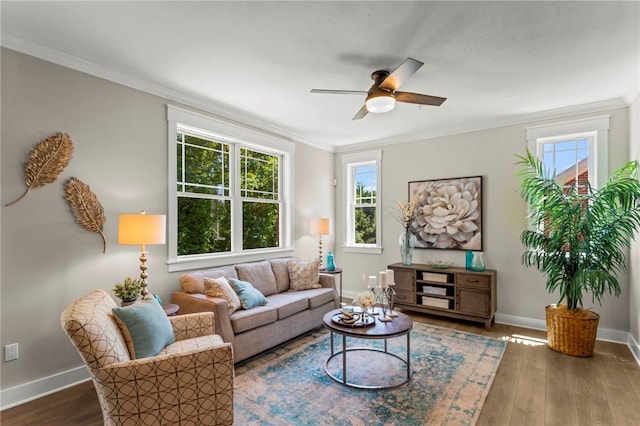 living room featuring wood-type flooring, crown molding, and ceiling fan