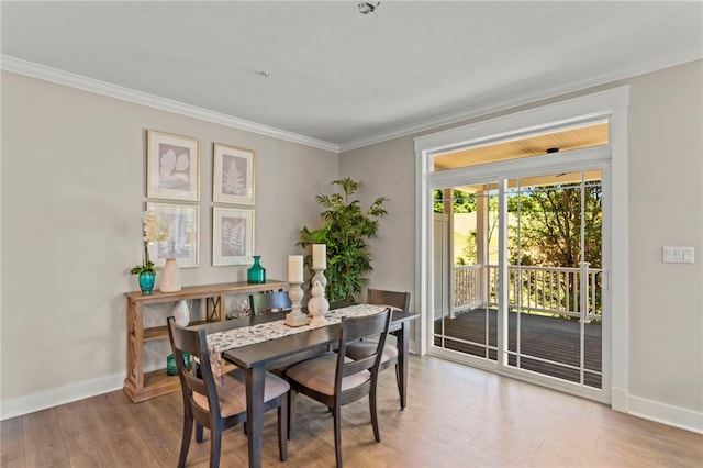 dining area with light wood-type flooring and ornamental molding