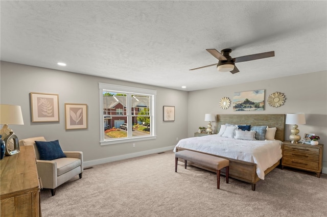 bedroom featuring carpet flooring, a textured ceiling, and ceiling fan