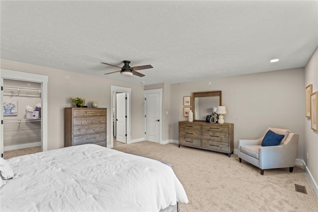 bedroom featuring a closet, carpet flooring, a textured ceiling, and ceiling fan