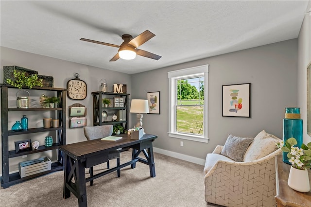 carpeted office space featuring a textured ceiling and ceiling fan