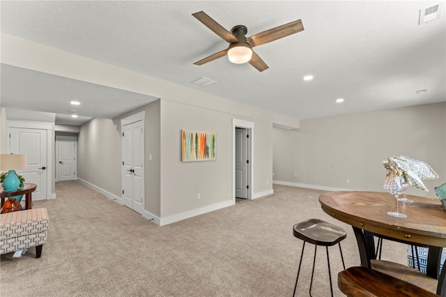 dining space featuring light colored carpet and ceiling fan