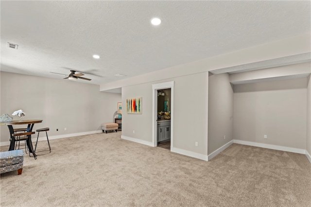 sitting room with carpet flooring, a textured ceiling, and ceiling fan