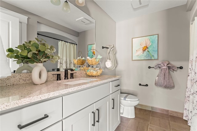 bathroom featuring vanity, tile patterned flooring, and toilet