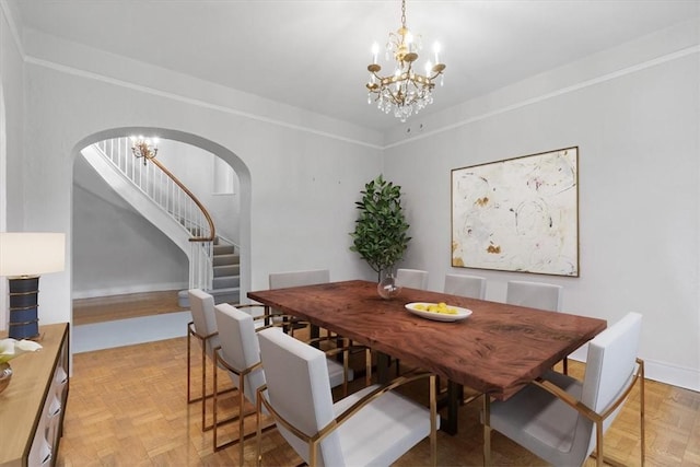 dining area with light parquet flooring and an inviting chandelier