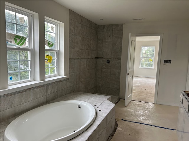 bathroom with plenty of natural light and separate shower and tub