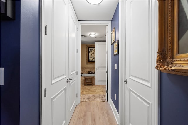 hallway with light hardwood / wood-style floors