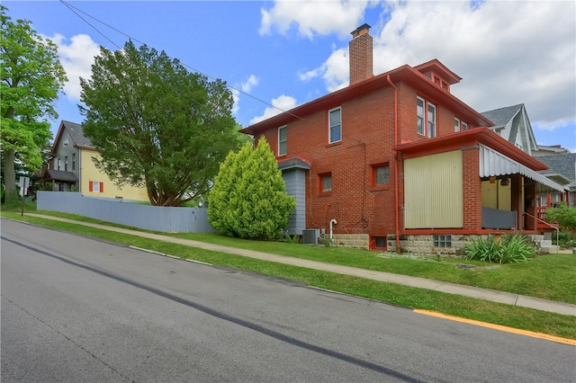 view of property exterior featuring a lawn and central AC unit