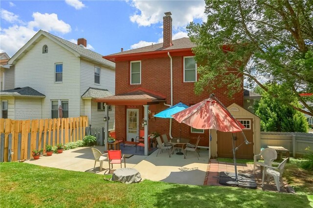 back of property featuring a patio area and a lawn