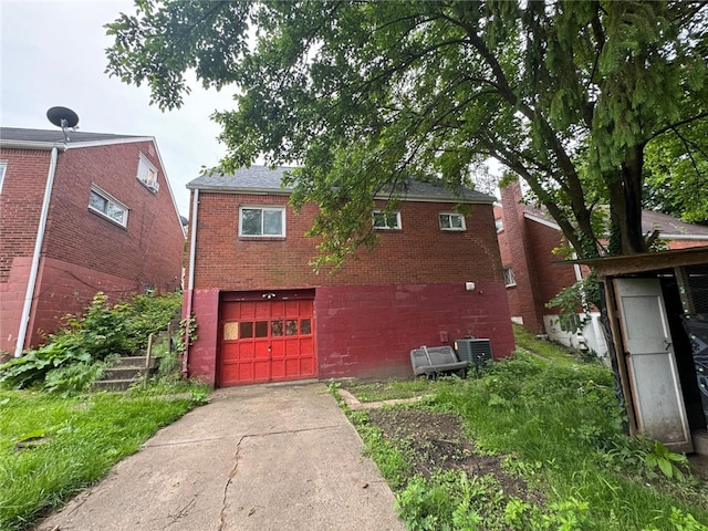 exterior space with a garage and central AC unit