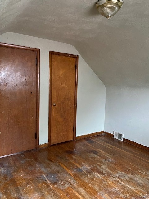 additional living space featuring vaulted ceiling and hardwood / wood-style floors