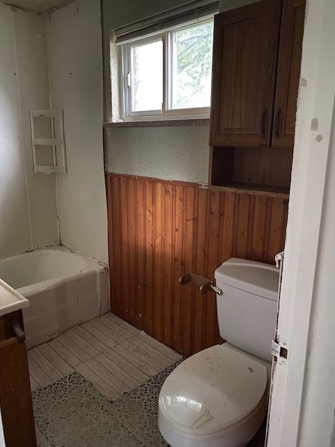 bathroom featuring wooden walls, tile patterned flooring, toilet, and vanity