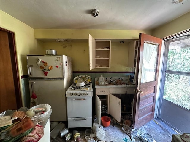 kitchen with white gas range and fridge