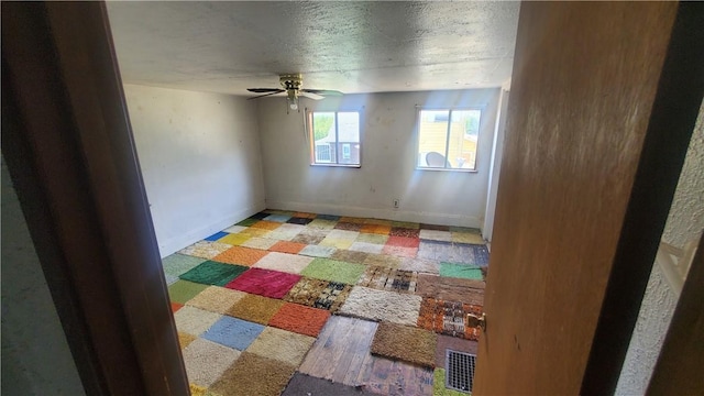 empty room featuring ceiling fan and a textured ceiling