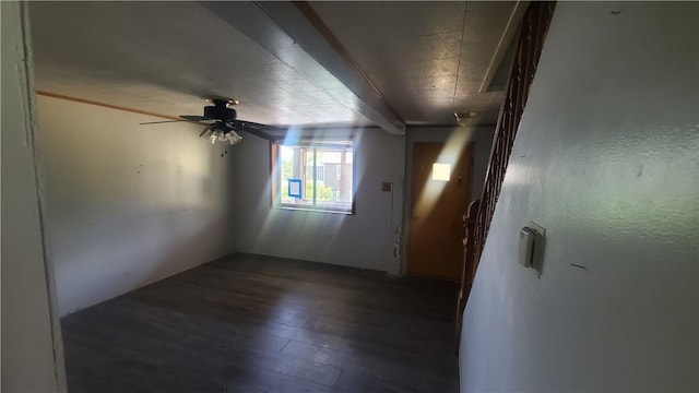 unfurnished room featuring dark wood-type flooring and ceiling fan