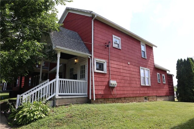 view of home's exterior with a porch and a yard