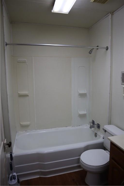 full bathroom featuring hardwood / wood-style flooring, toilet, shower / washtub combination, and vanity