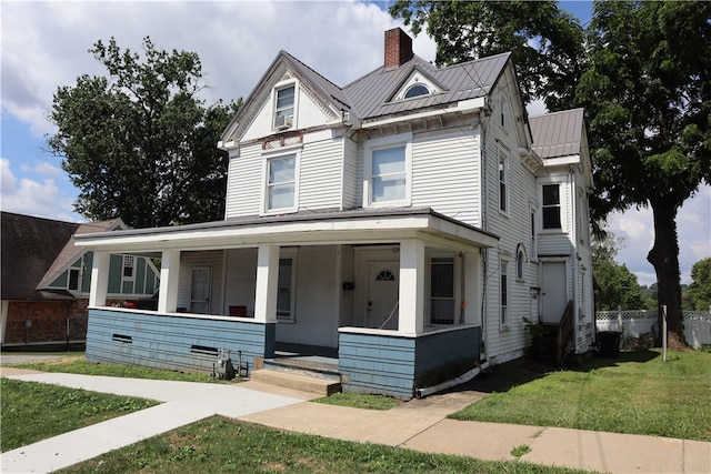 view of front of home with covered porch and a front lawn