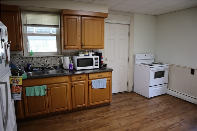 kitchen with a paneled ceiling, tasteful backsplash, white appliances, sink, and dark hardwood / wood-style floors